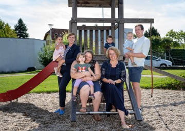 Sophie mit Mama Kathrin und Landesrätin Christiane Teschl-Hofmeister (vorne v.l.), Bürgermeisterin Barbara Kainz mit Natasha, der kleine Lino und Max mit Papa Lukas am Spielplatz des Kindergarten Pöchlarn.