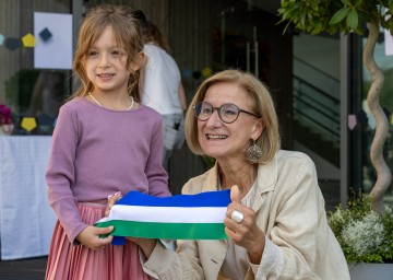 Landeshauptfrau Johanna Mikl-Leitner mit einem Kindergartenkind nach dem Durchschneiden des Bandes bei der Kindergarteneröffnung bzw. Eröffnung der Tagesbetreuungseinrichtung in der Marktgemeinde Leobersdorf.